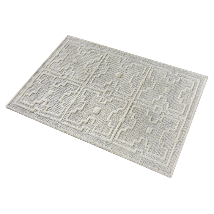 Chattan handwoven New Zealand wool rug with raised ivory diamonds on stone grey, in a living room