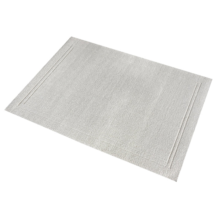 Margin handwoven ivory wool rug with a raised tonal border, in a living room