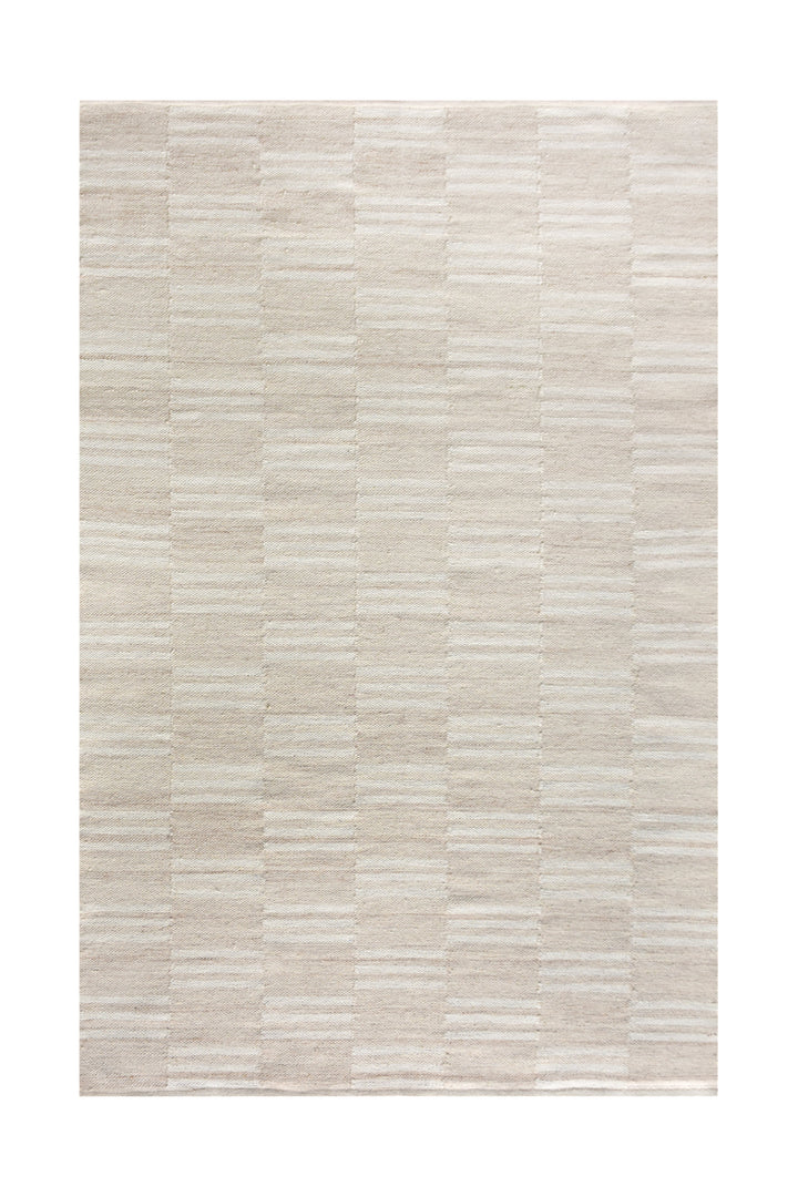Parat handwoven wool rug in cream and oatmeal with vertical block stripes, in a bedroom