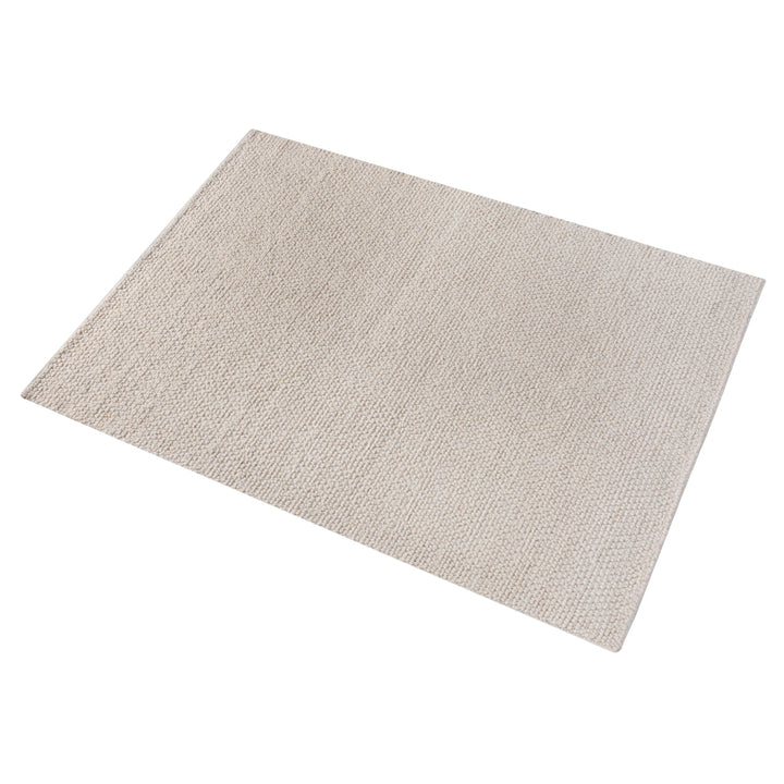 Bunai handwoven wool rug with a chunky looped bouclé surface in oatmeal, in a living room