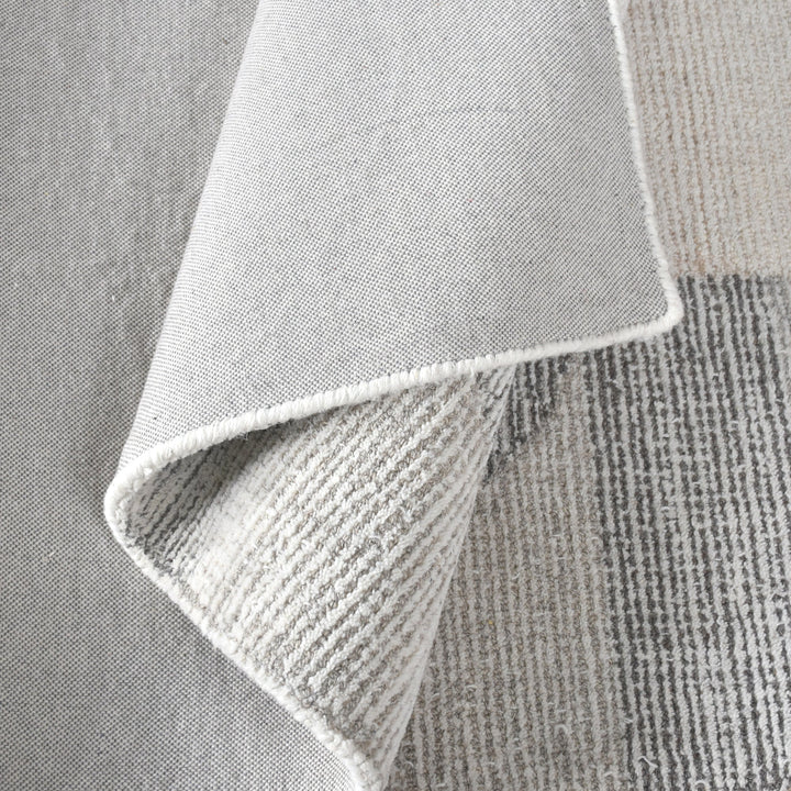 Ghera handwoven pale grey wool rug with overlapping cream circles, in a living room