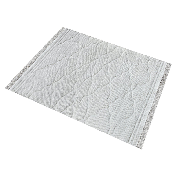 Kangan tufted wool rug with a tonal carved Moroccan lattice in bone ivory, in a bedroom