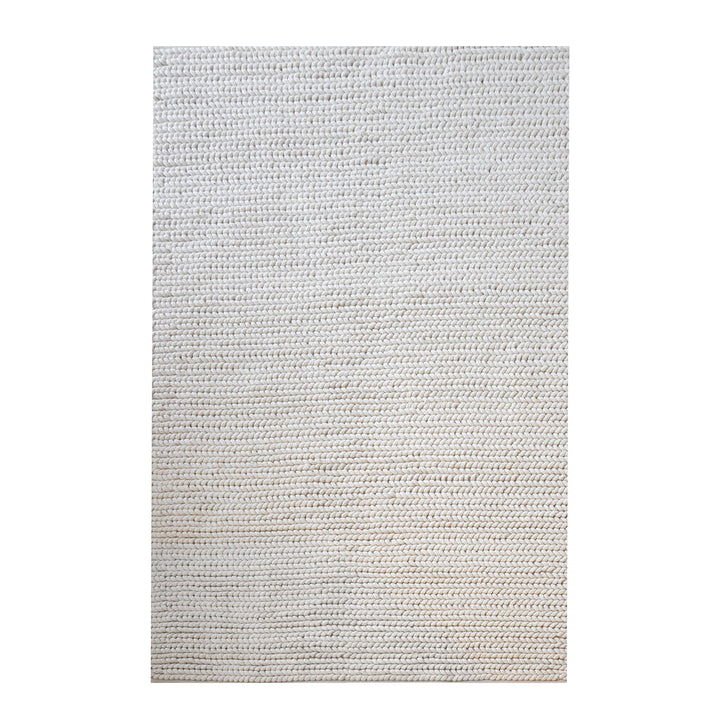 Dor handwoven chunky wool rug in charcoal, woven in thick cords, in a living room