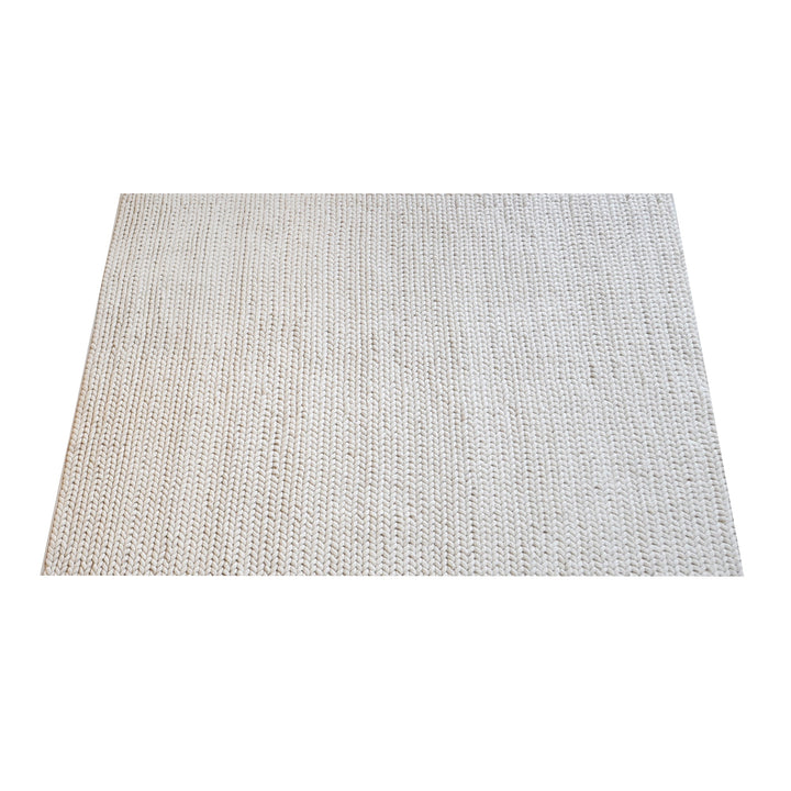 Dor handwoven chunky wool rug in charcoal, woven in thick cords, in a living room