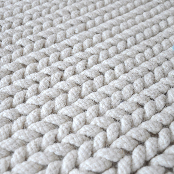 Dor handwoven chunky wool rug in charcoal, woven in thick cords, in a living room