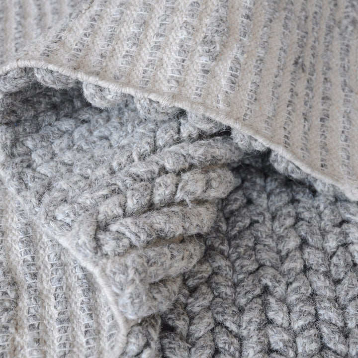 Dor handwoven chunky wool rug in charcoal, woven in thick cords, in a living room