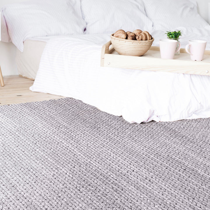 Dor handwoven chunky wool rug in charcoal, woven in thick cords, in a living room