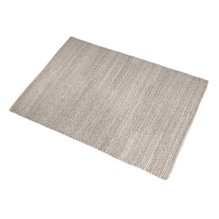 Dor handwoven chunky wool rug in charcoal, woven in thick cords, in a living room