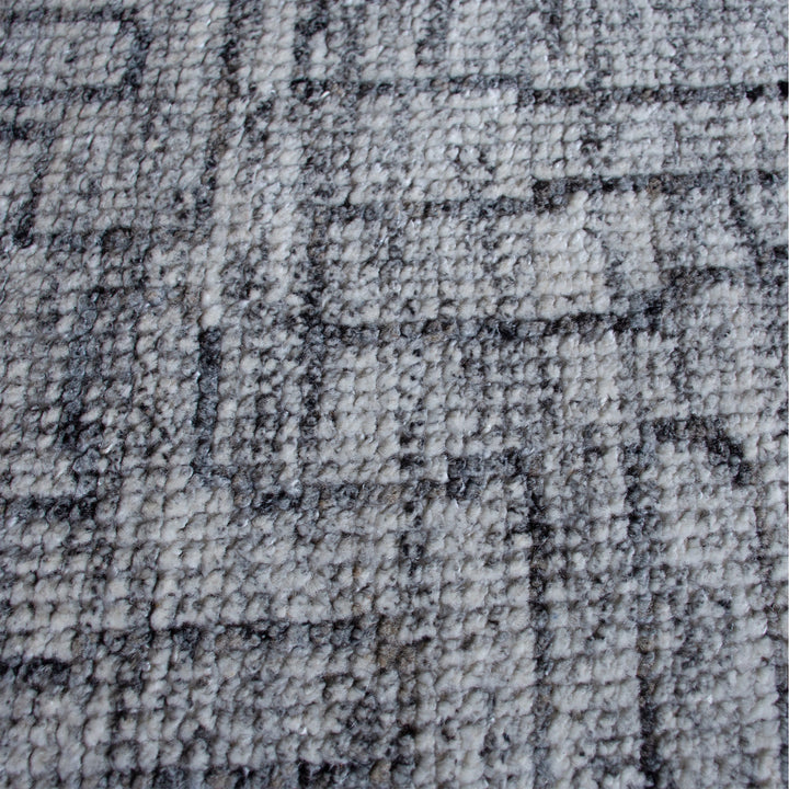 Barsaat hand-knotted wool and viscose rug with mottled blue-grey brick lines, in a living room