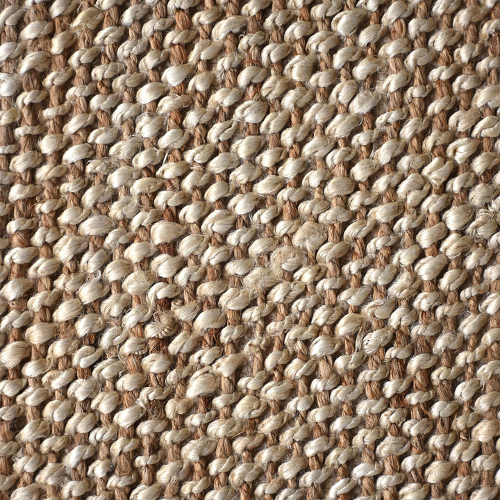 Chaukhat handwoven flatweave jute and wool rug in jute tan with a rust-brown border, in a living room