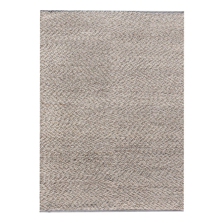Mitti handwoven wool rug with a nubby looped weave in warm beige and brown, in a living room