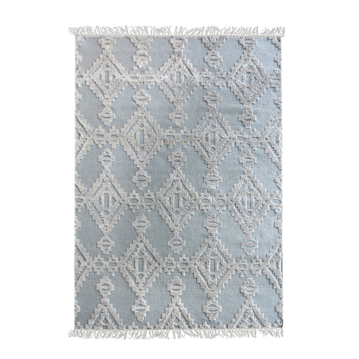 Mor hand-knotted wool rug with ivory raised diamonds on duck egg blue, in a bedroom