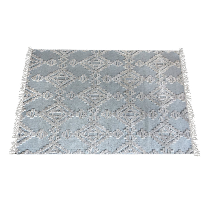 Mor hand-knotted wool rug with ivory raised diamonds on duck egg blue, in a bedroom