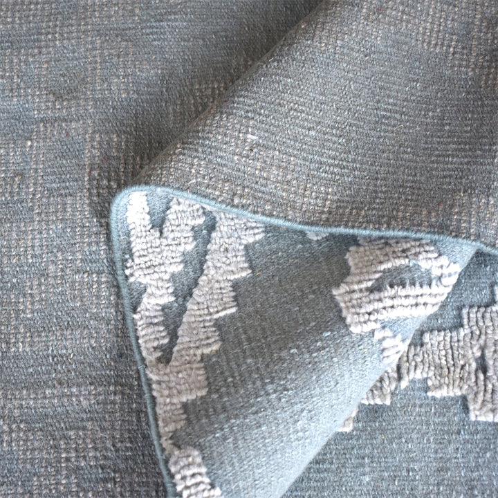 Mor hand-knotted wool rug with ivory raised diamonds on duck egg blue, in a bedroom