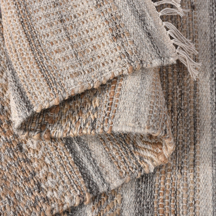 Deckchair handwoven jute and wool rug with broad ivory and tan stripes, in a living room