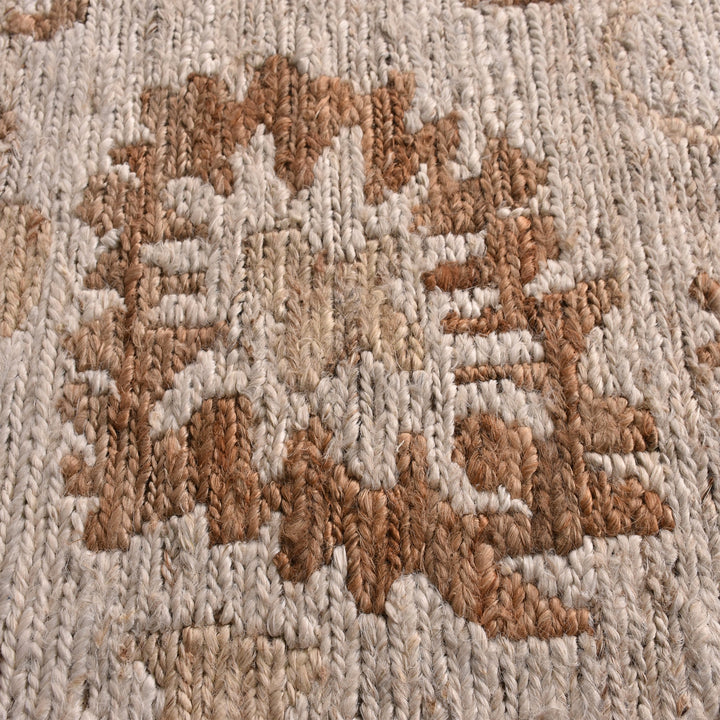 Peony hand-knotted ivory jute rug with faded terracotta florals, in a living room