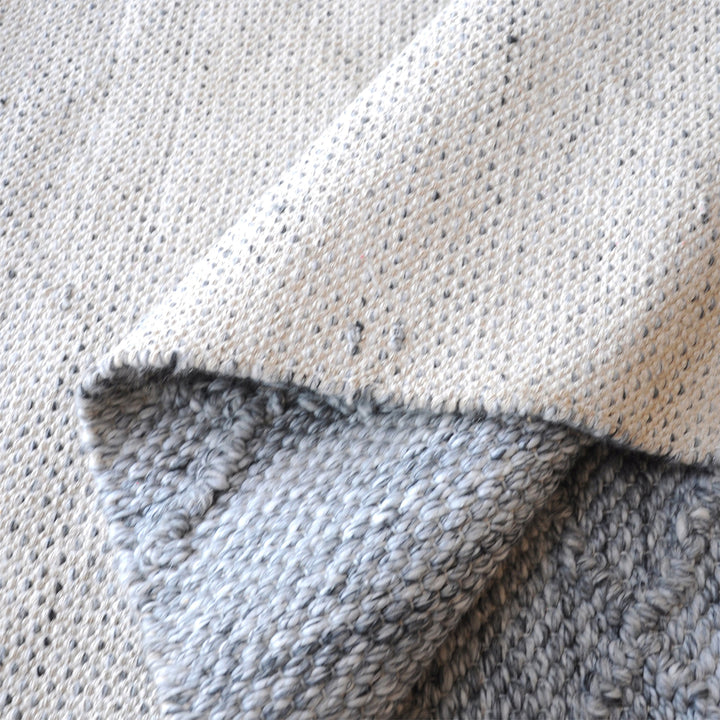 Razai handwoven recycled PET rug with a taupe diamond-quilted raised weave, on a patio