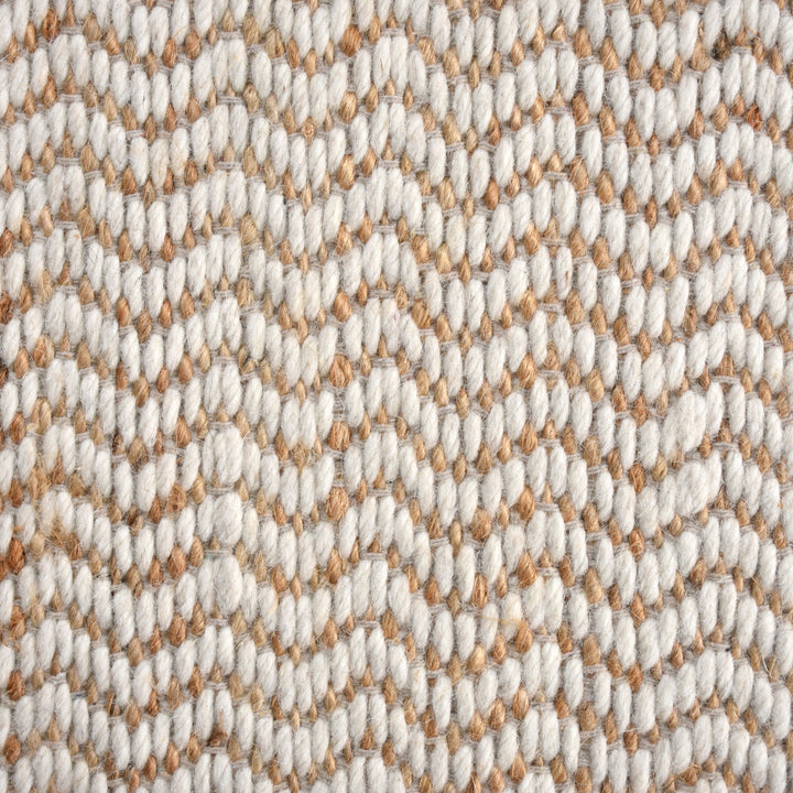 Chevron handwoven cream wool and jute rug with a herringbone chevron weave, in a living room