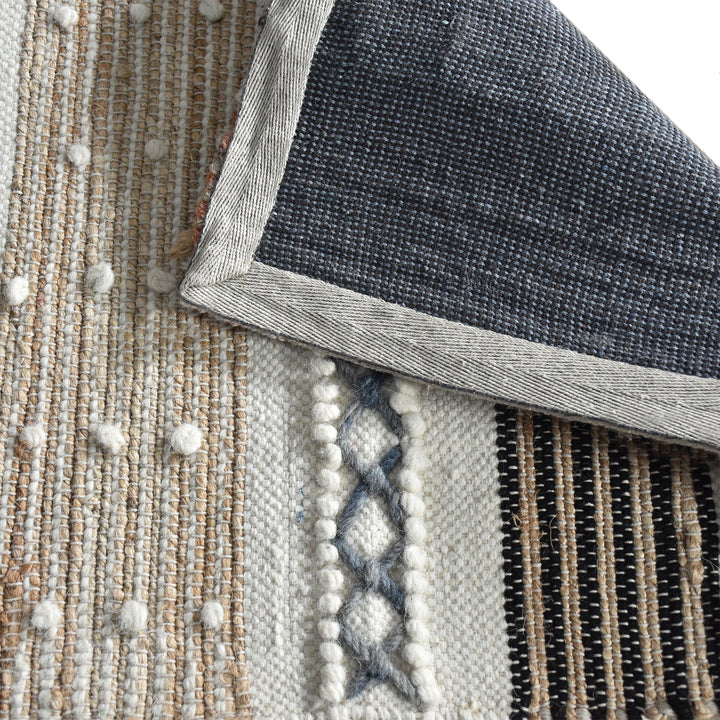 Bunting handwoven hemp and wool rug with horizontal rust, charcoal and ivory stripes, in a study
