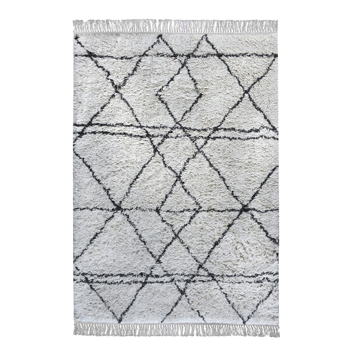 Lipi tufted cotton shag rug in ivory with a bold black lattice, in a bedroom