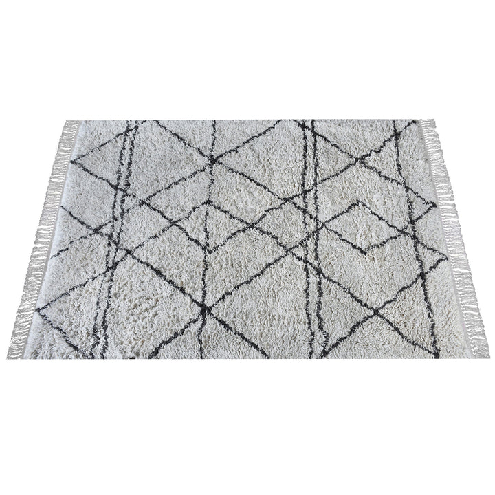 Lipi tufted cotton shag rug in ivory with a bold black lattice, in a bedroom