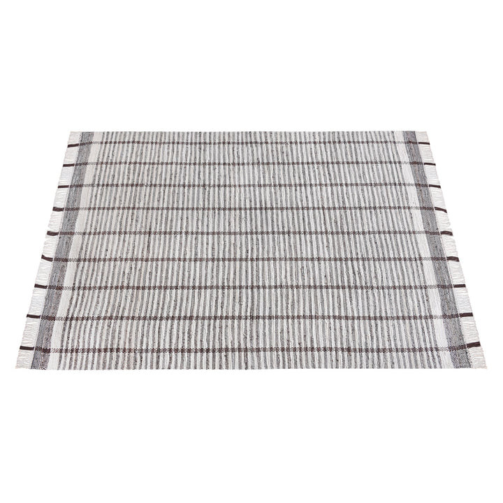 Awning handwoven denim and cotton rug with broad grey and ivory stripes, in a living room