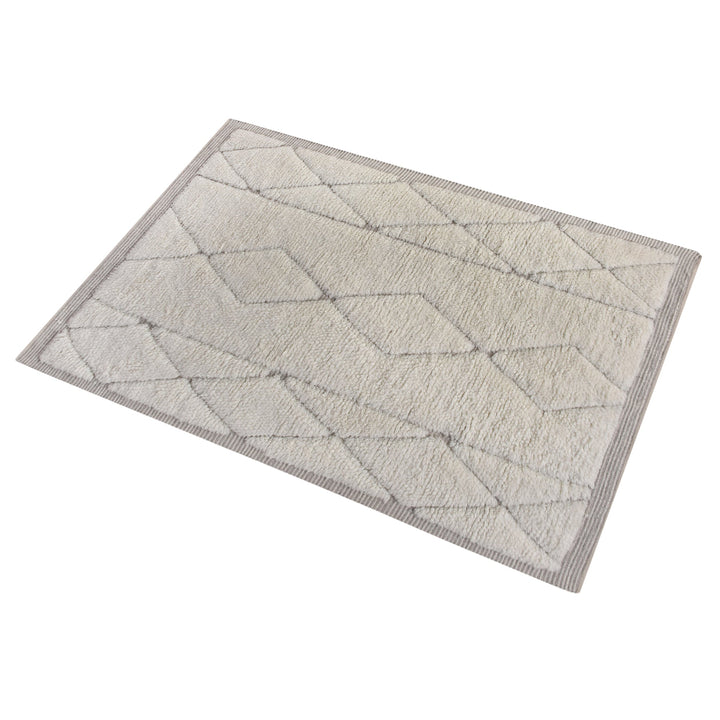 Ola handwoven New Zealand wool rug with an ivory Moroccan diamond lattice and grey, in a living room