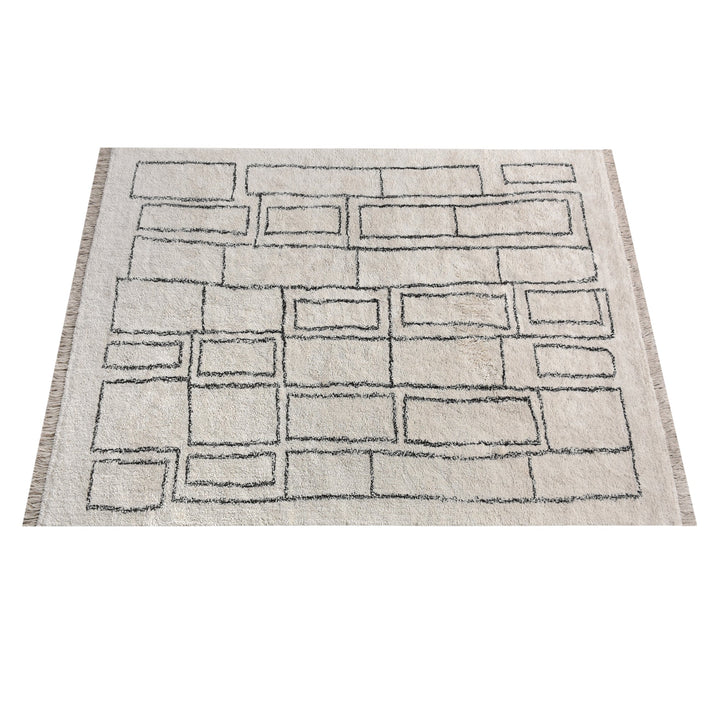 Eent tufted cotton rug with charcoal rectangle grid on ivory, in a bedroom