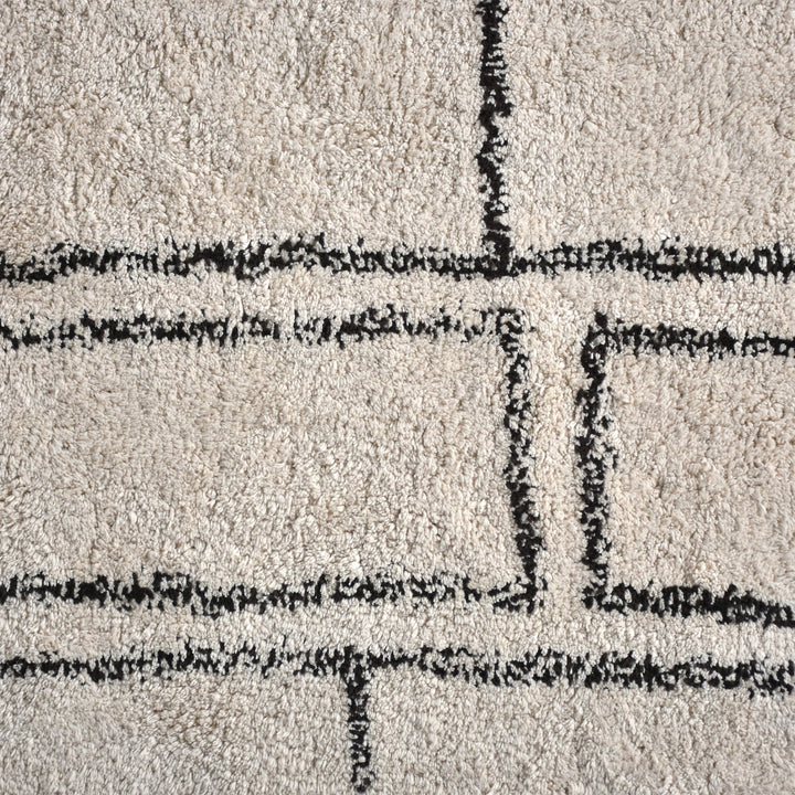 Eent tufted cotton rug with charcoal rectangle grid on ivory, in a bedroom