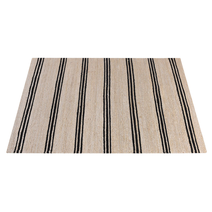 Khaat handwoven natural jute rug with black stripes, in a living room
