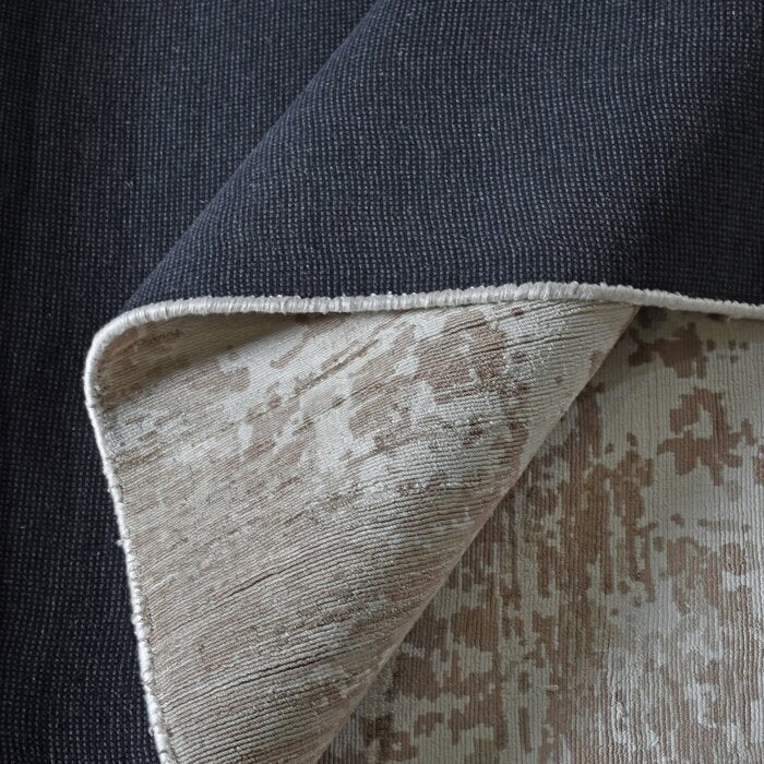 Parchhai handwoven viscose rug with an erased medallion on pale silver beige, in a living room