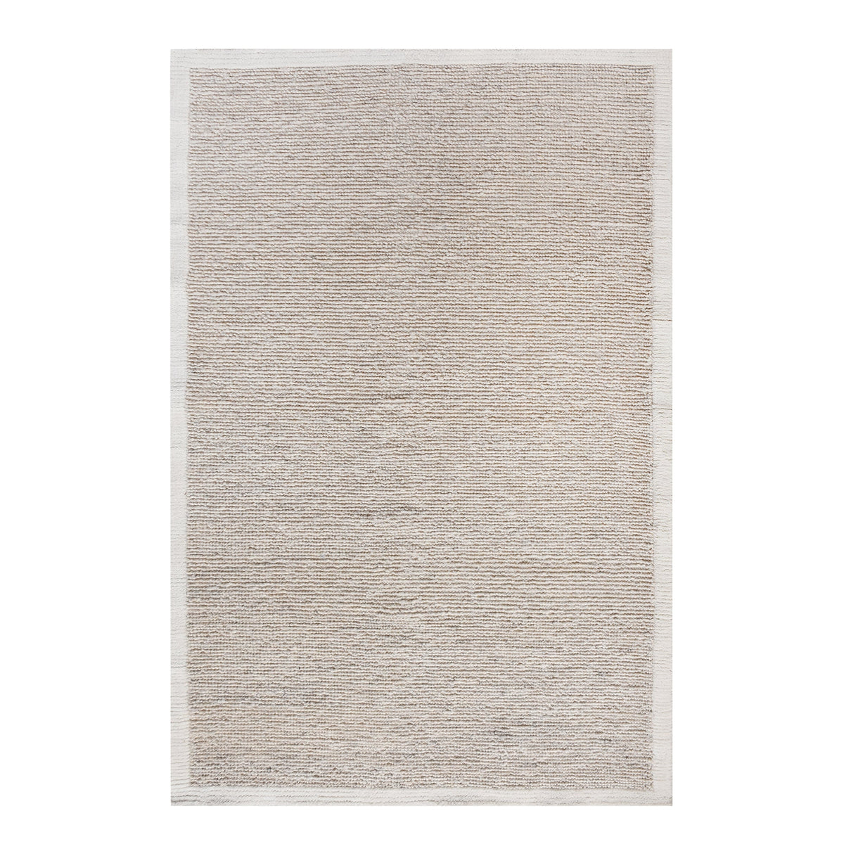Shant handwoven flatweave wool rug in natural ivory with fine ribs and fringe, beside a bed