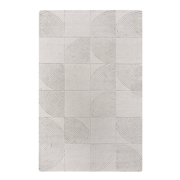 Seashell handwoven ivory wool rug with carved concentric arc tiles, in a bedroom