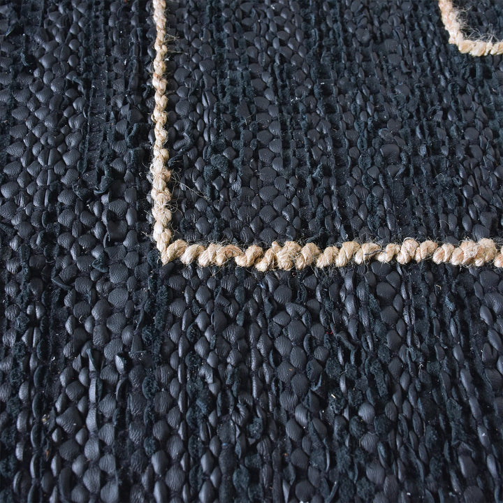 Aasmaan handwoven hemp and leather rug with cream nested angles on midnight navy, in a study