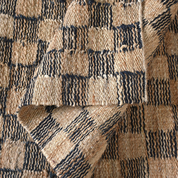 Chessboard handwoven jute rug with natural and charcoal checkerboard, in a living room