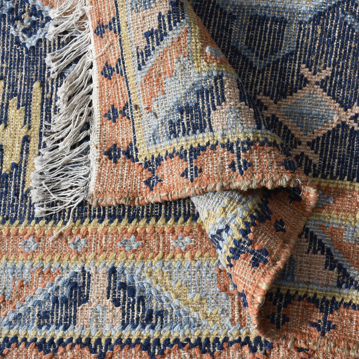 Harbour flatweave navy wool and hemp kilim rug with gold and rust medallions, in an entryway