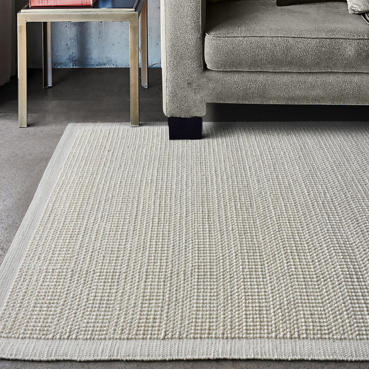 Basket handwoven cream wool rug with basketweave texture and tonal border, in a bedroom