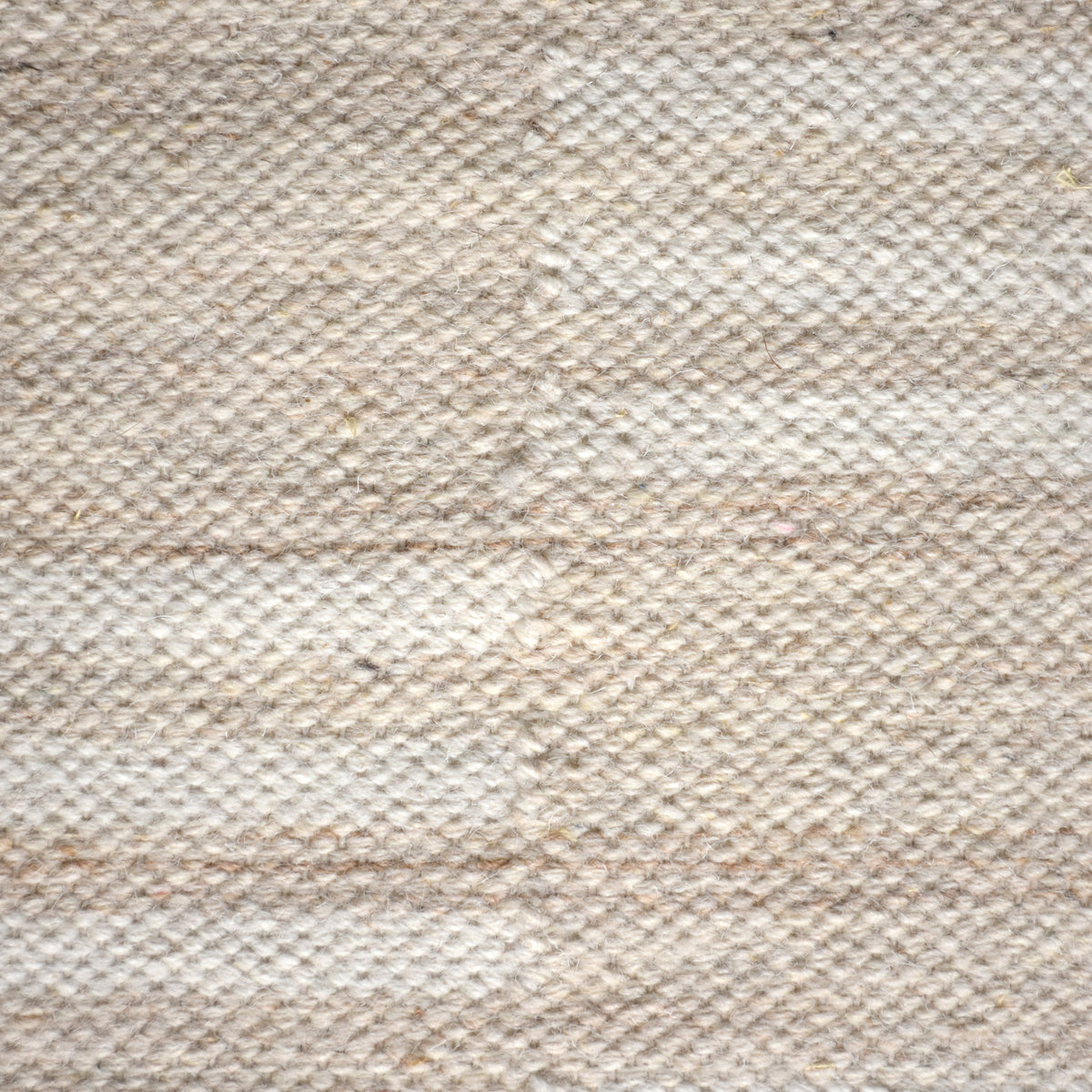 Parat handwoven wool rug in cream and oatmeal with vertical block stripes, in a bedroom