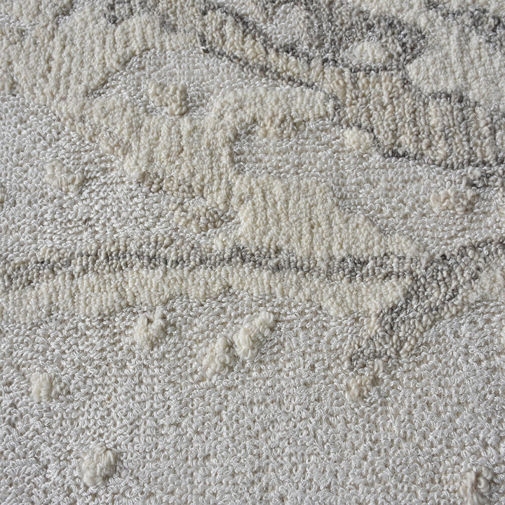 Daali handwoven wool and viscose rug with grey carved branch lines on ivory, in a bedroom