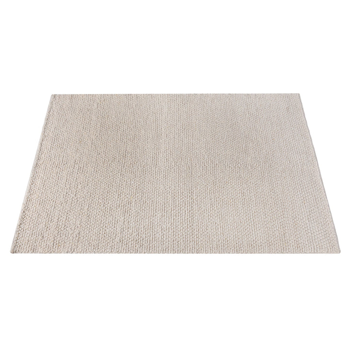 Bunai handwoven wool rug with a chunky looped bouclé surface in oatmeal, in a living room