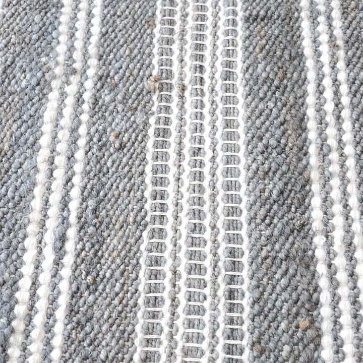 Pinstripe handwoven hemp and wool rug with slate and ivory vertical stripes, in a hallway