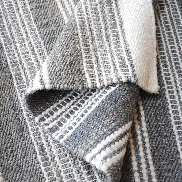Pinstripe handwoven hemp and wool rug with slate and ivory vertical stripes, in a hallway