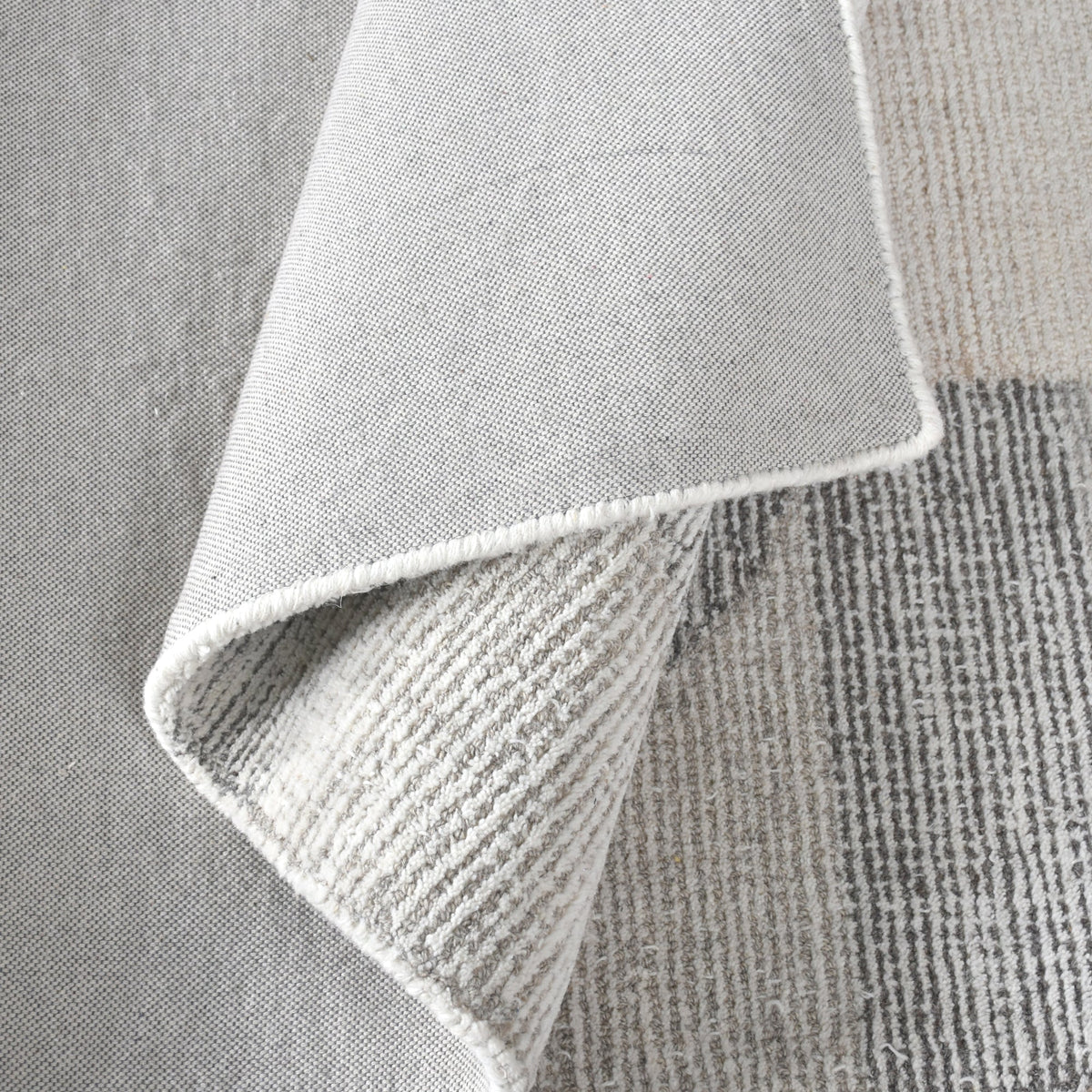 Ghera handwoven pale grey wool rug with overlapping cream circles, in a living room