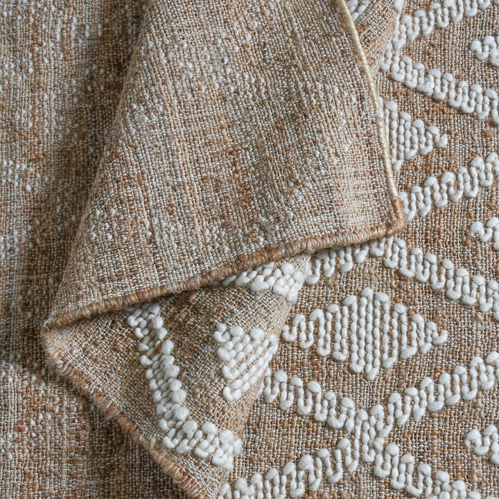 Thistle flatweave jute and wool rug with ivory tufted diamonds on taupe, in a living room