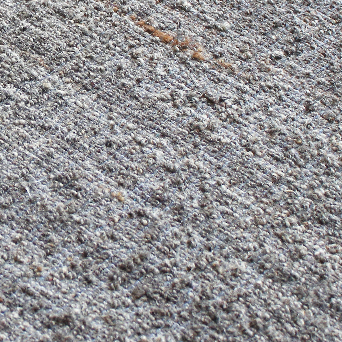Saada handwoven flat wool rug in solid stone beige with charcoal, in a living room