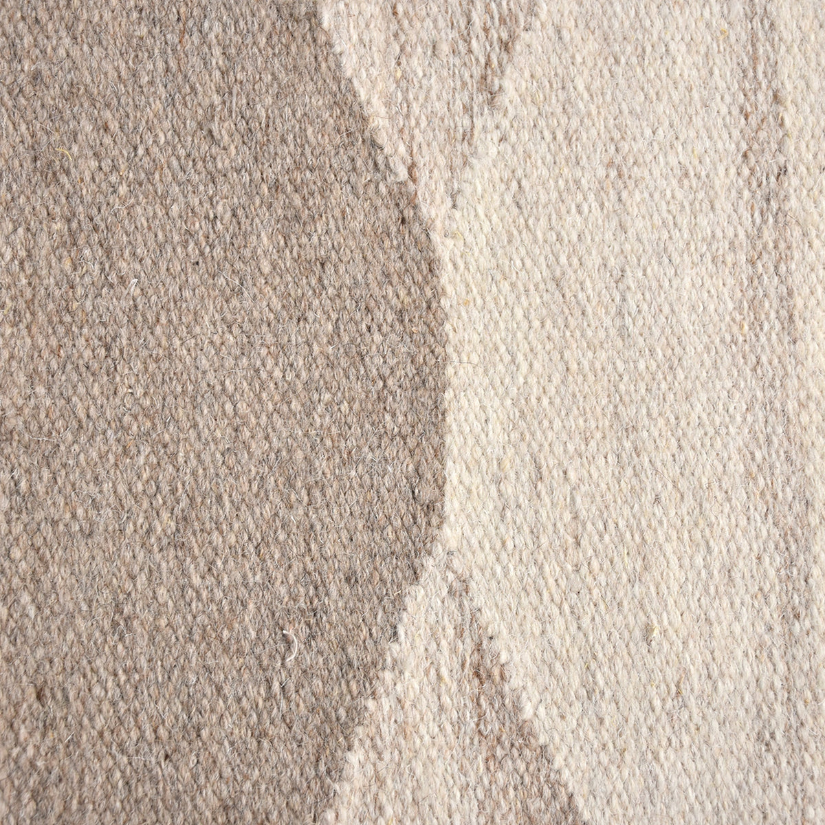 Chhatri handwoven wool rug with bold ivory and beige arch blocks, in a living room