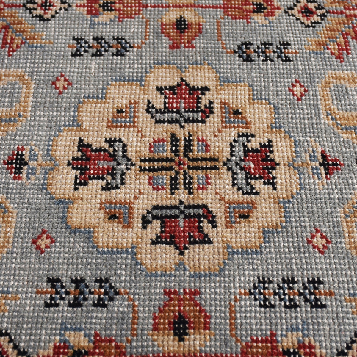 Manor hand-knotted slate grey wool rug with rust and red medallions, in a dining room