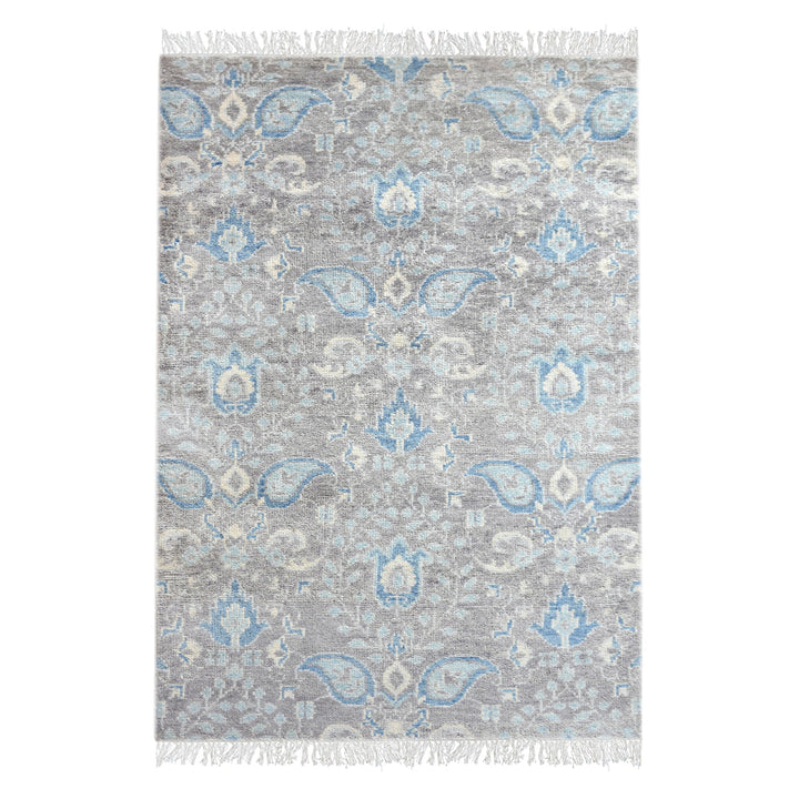 Kairi hand-knotted wool rug with blue paisley on a distressed taupe ground, in a living room