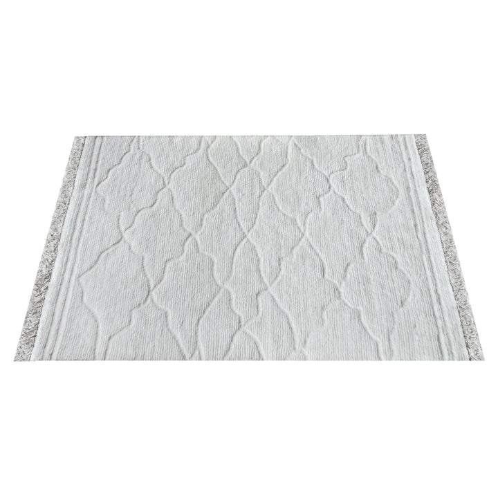 Kangan tufted wool rug with a tonal carved Moroccan lattice in bone ivory, in a bedroom