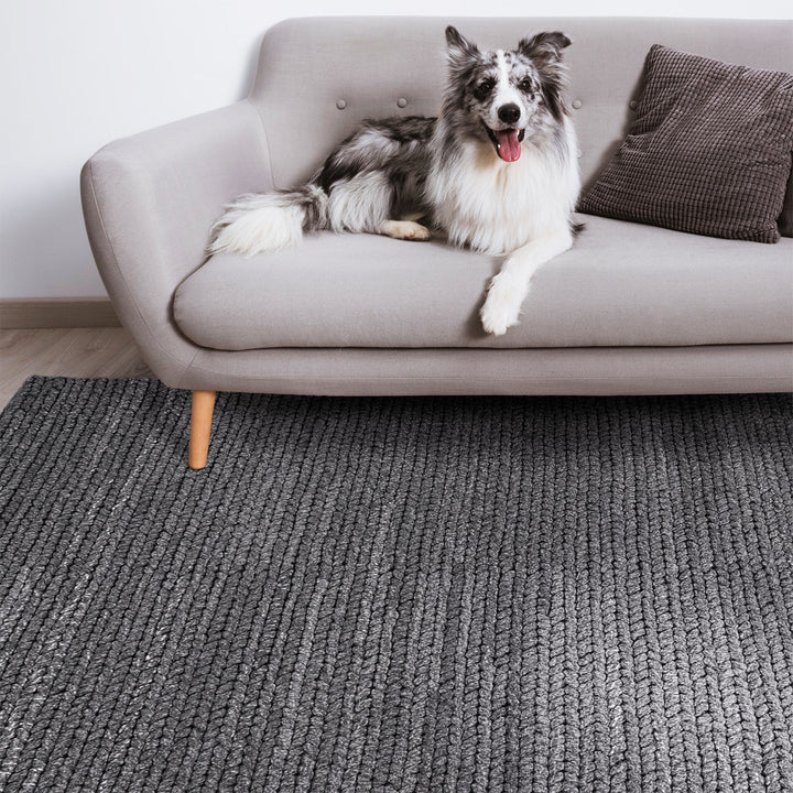 Dor handwoven chunky wool rug in charcoal, woven in thick cords, in a living room